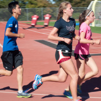 Cross country team members condition on the track during an afternoon practice.