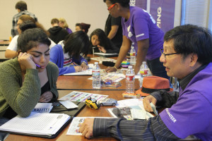 A volunteer explains real world obstacles to a student at the Bite of Reality workshop.