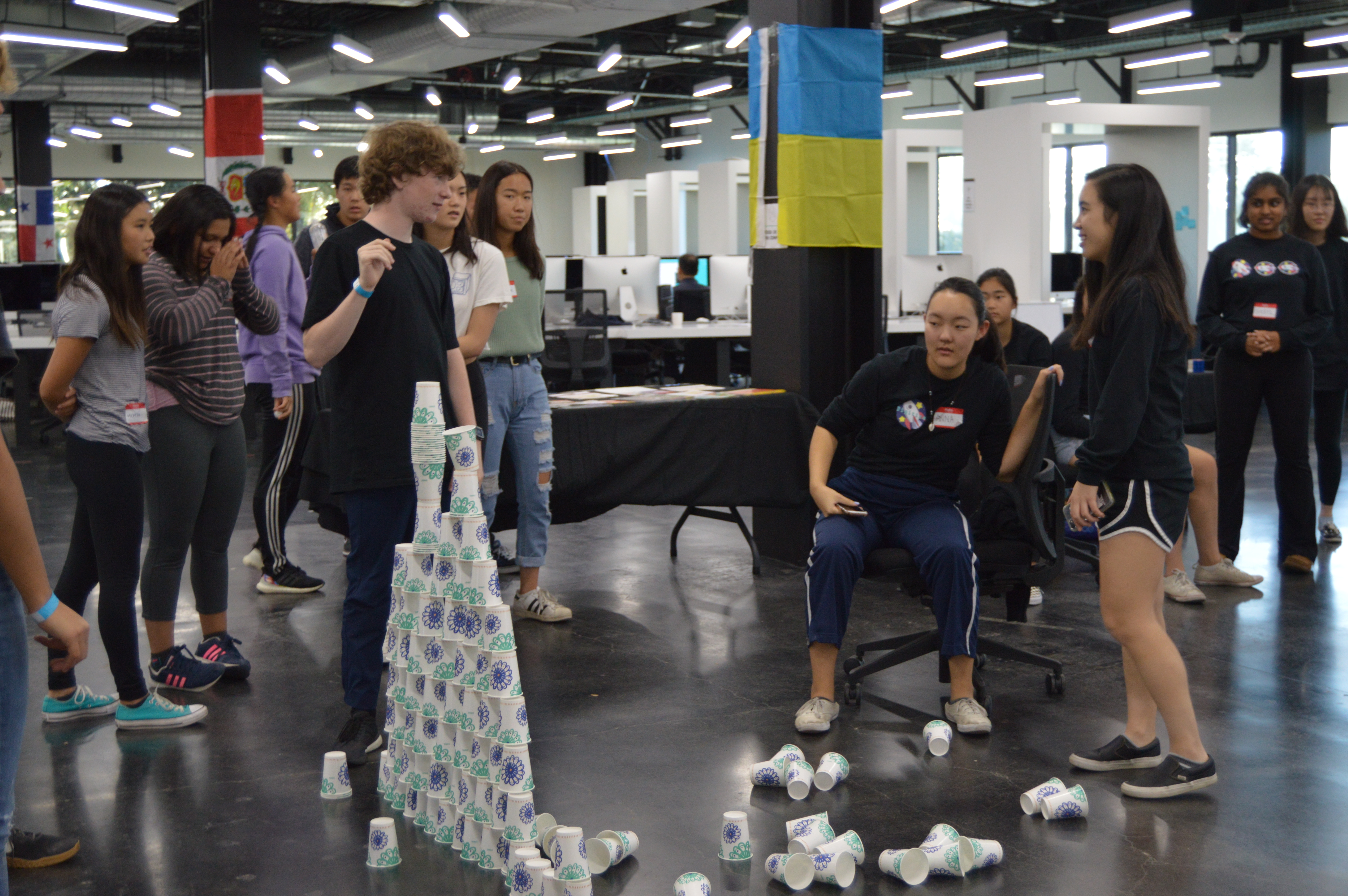 Students play a cup stacking game to bond at the hackathon.