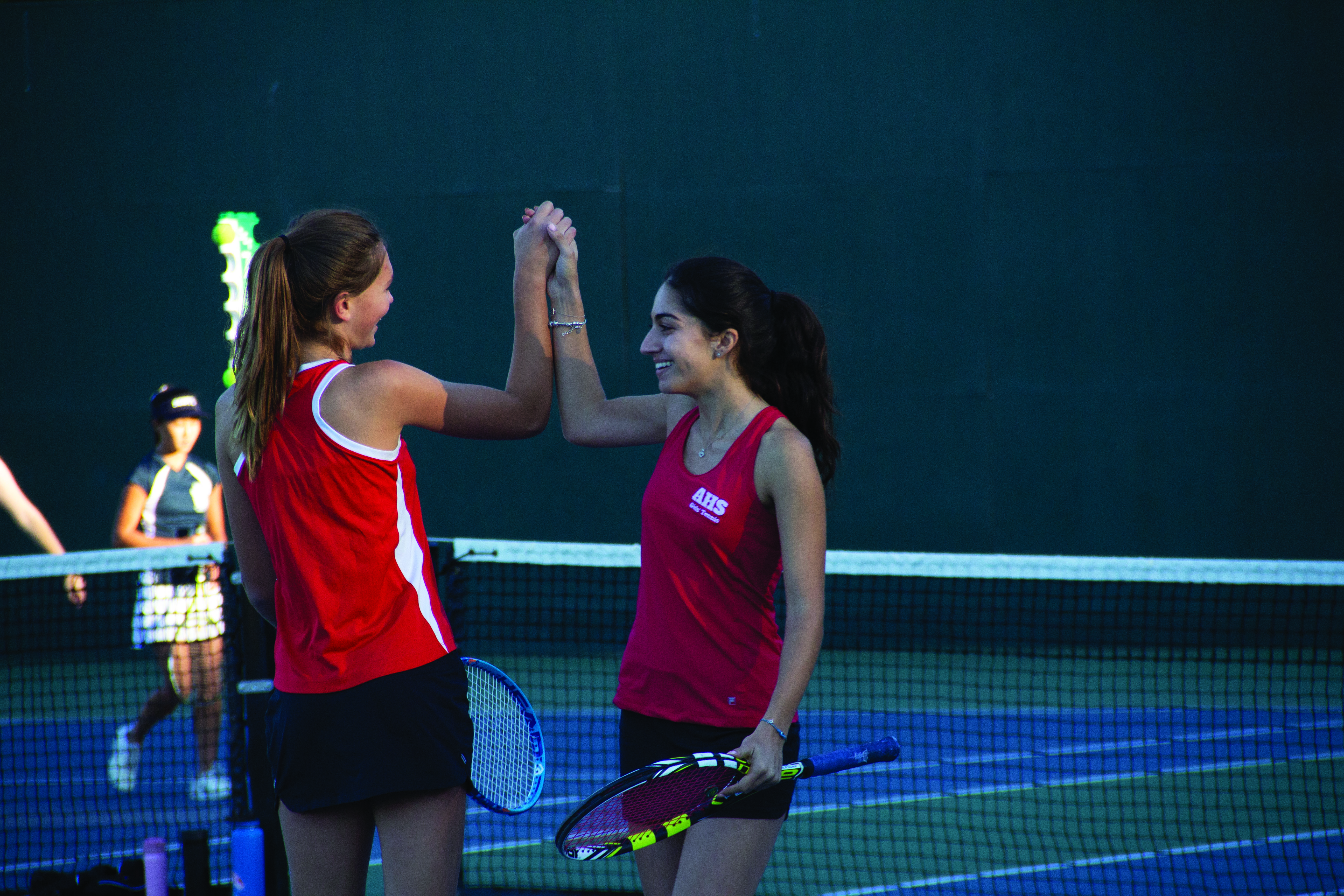 Seniors Yasmina Malouf and Marie Pachtner high five after winning a point.